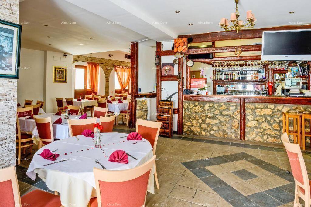 Geräumiger Restaurantbereich mit mehreren Tischen, einer Bar und rustikalen Holzelementen.