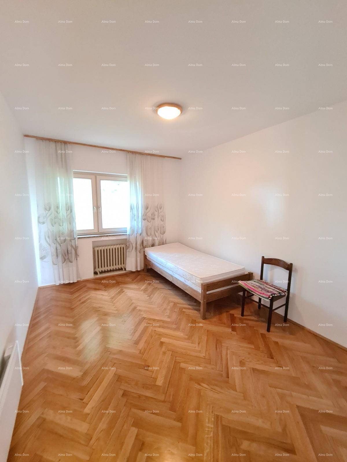 Helles Schlafzimmer mit Parkettboden, Einzelbett und Fenster mit Heizkörper.