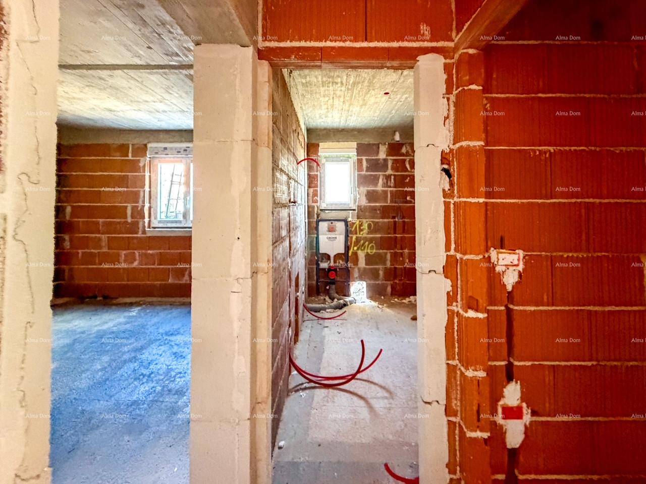 Blick durch eine Türöffnung in einen weiteren Raum im Rohbau mit Ziegelwänden.