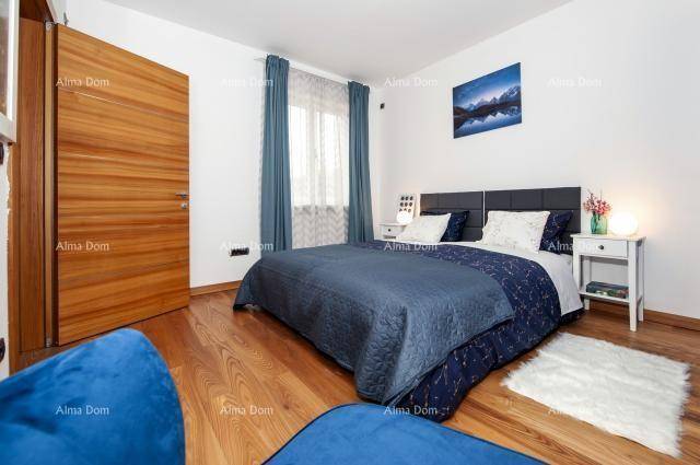 Helles Schlafzimmer mit Holzboden, blauen Vorhängen und modernem Bett.