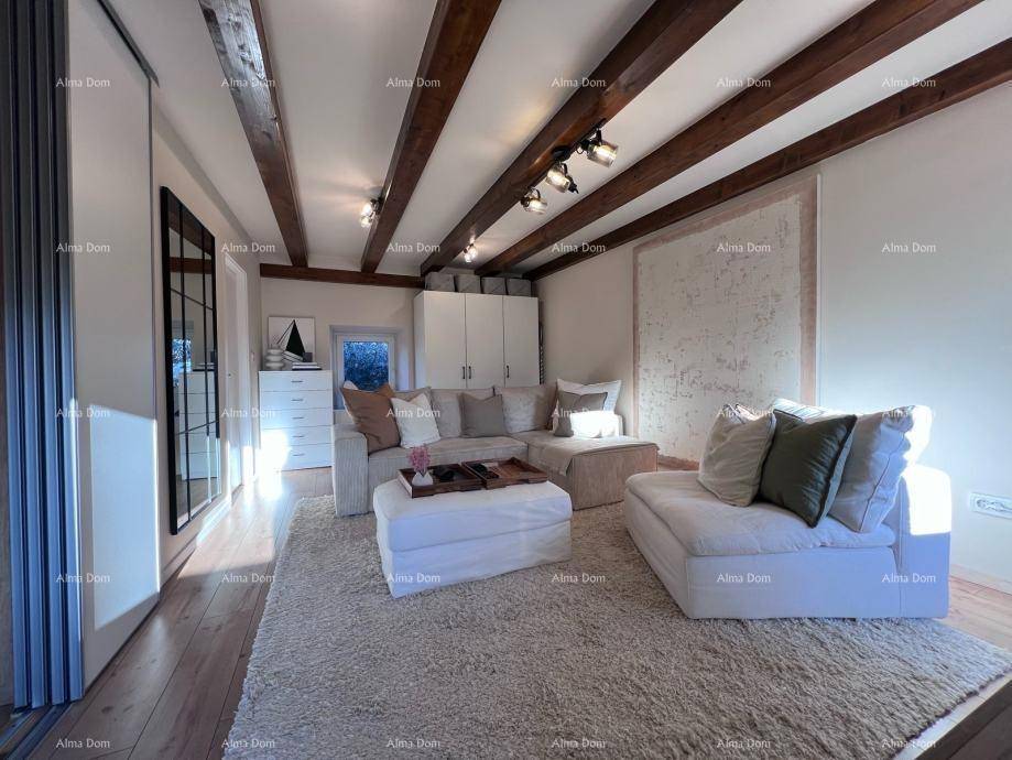 Gemütliches Wohnzimmer mit großem Ecksofa, weichem Teppich und rustikalen Holzbalken an der Decke.