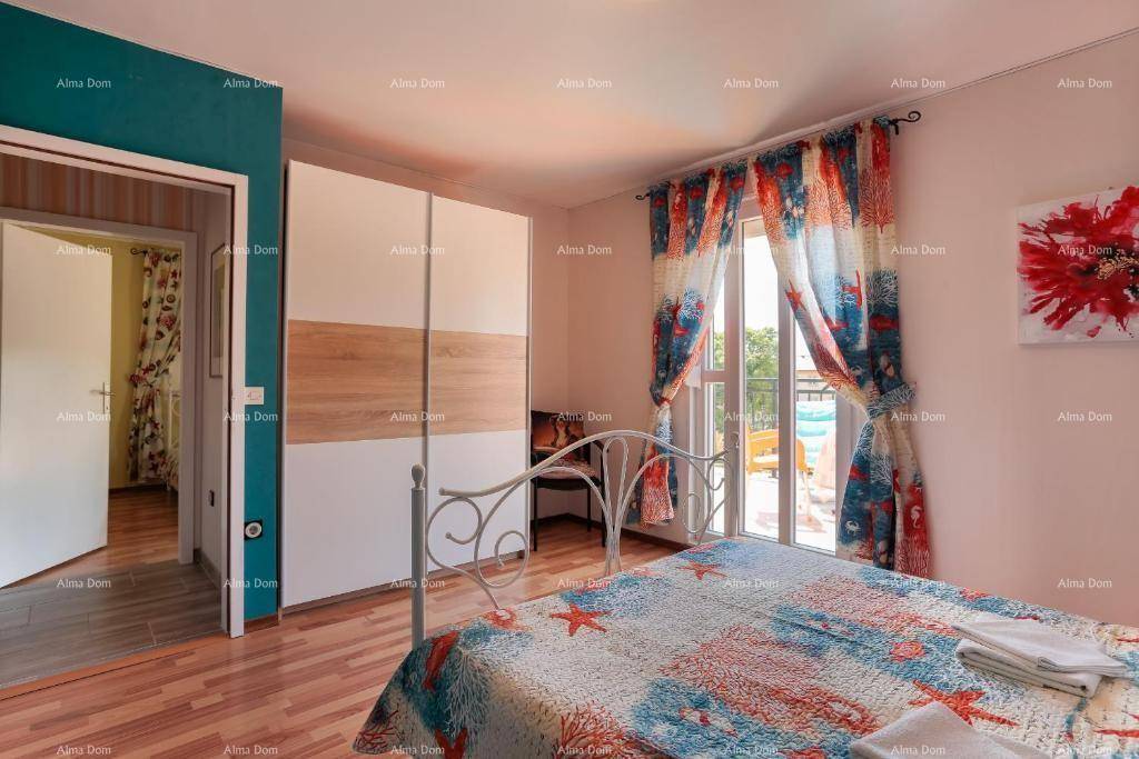 Schlafzimmer mit Doppelbett, großem Kleiderschrank und Zugang zu einem Balkon mit Blick ins Freie.