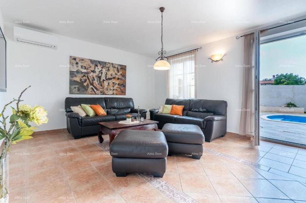 Helles Wohnzimmer mit bequemen Ledersofas, Fliesenboden und Zugang zur Außenterrasse.