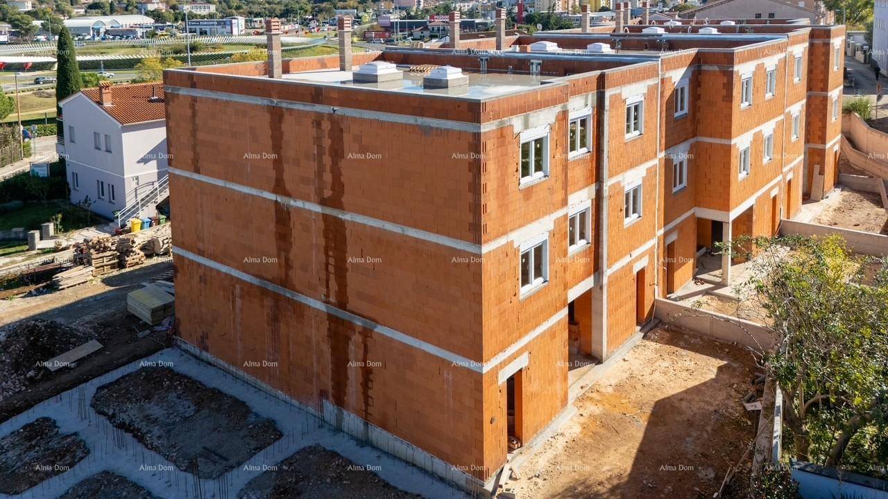 Seitenansicht des Neubaus im Rohbau mit sichtbaren Ziegelwänden und Fenstern.