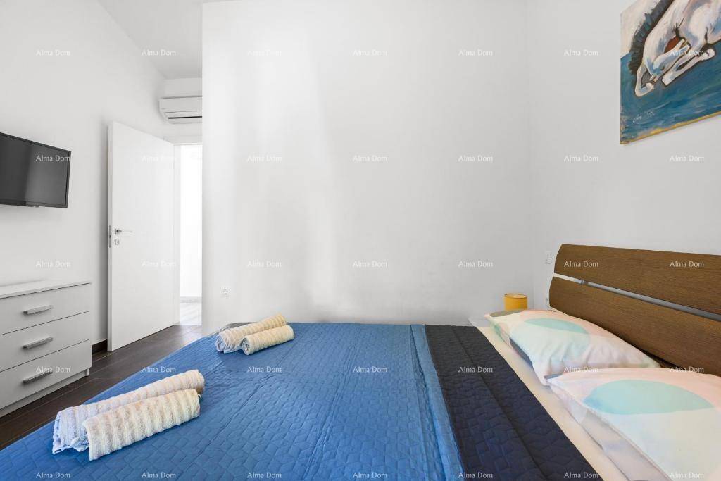 Schlafzimmer mit Doppelbett, dunklem Holzboden und Klimaanlage, hell und modern.