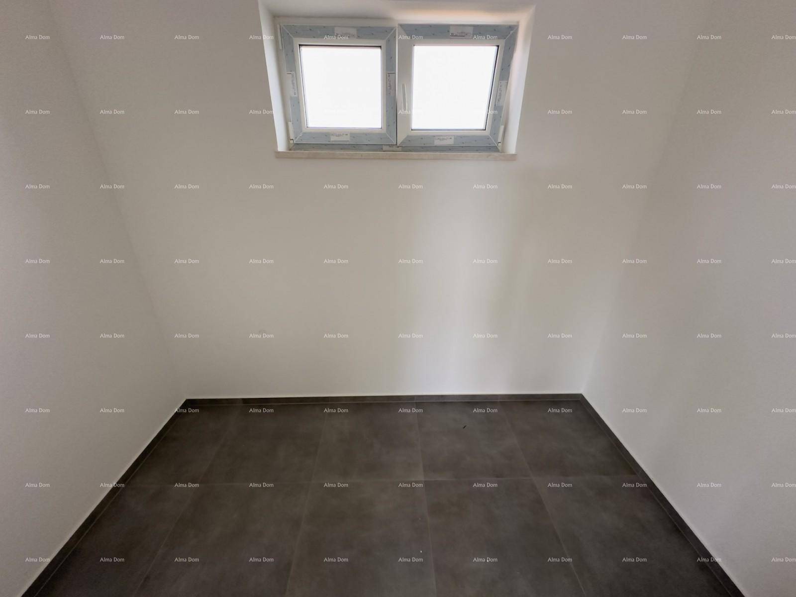 Dachgeschossraum im Rohbau mit schräger Decke und einem Dachfenster, das Tageslicht spendet.