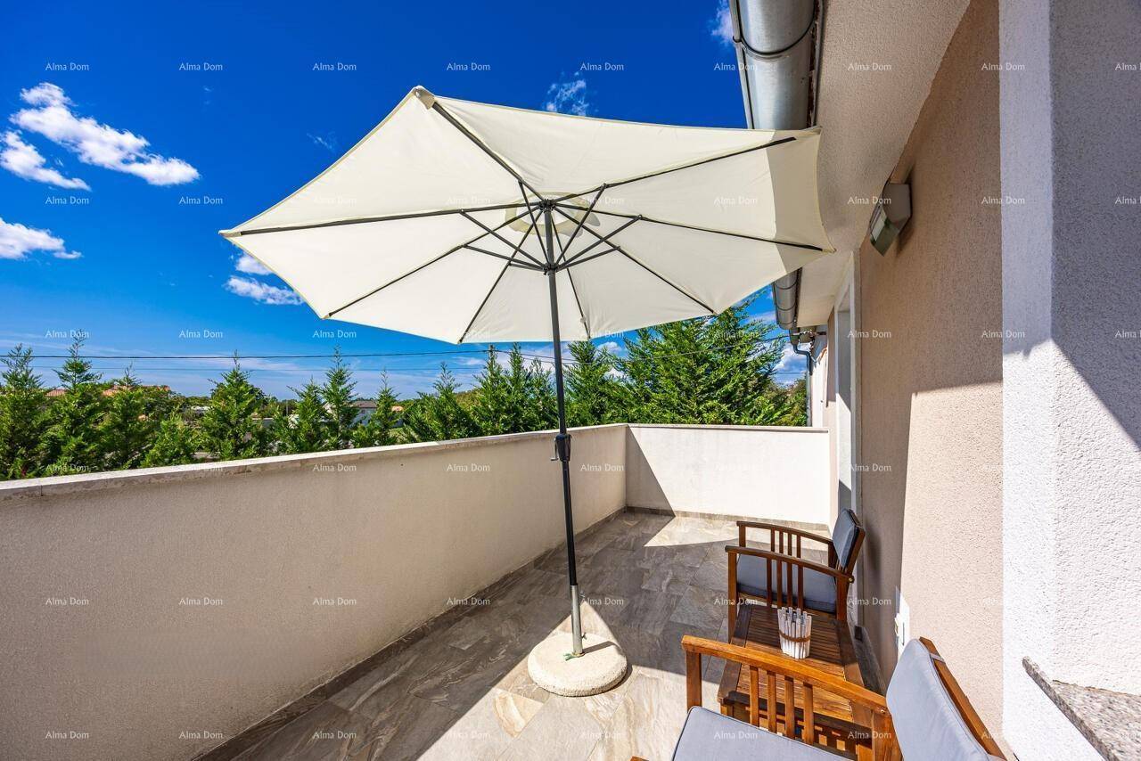 Sonniger Balkon mit Sitzgelegenheiten, Sonnenschirm und weitem Blick in die Umgebung.