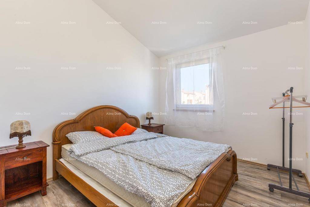 Gemütliches Schlafzimmer mit klassischem Holzdoppelbett, Nachttischen und Fenster.
