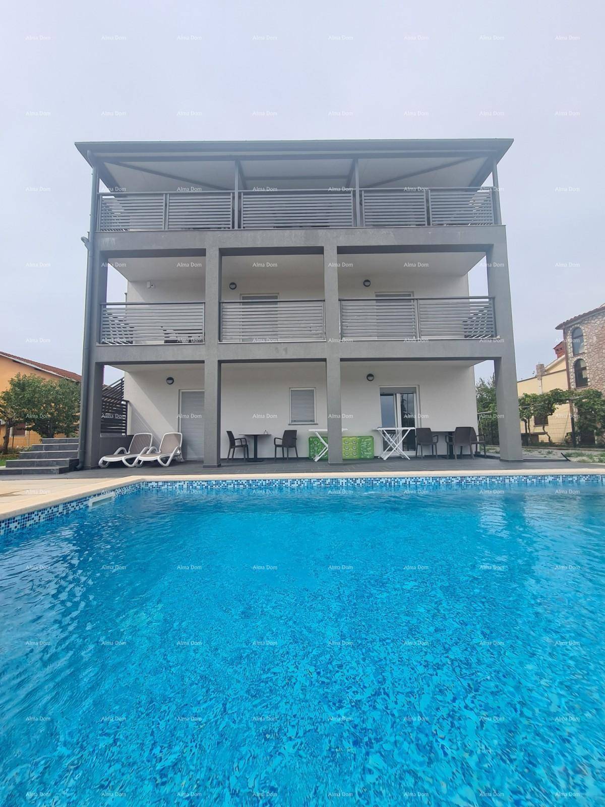 Modernes Apartmentgebäude mit mehreren Balkonen und einem großen Außenpoolbereich.