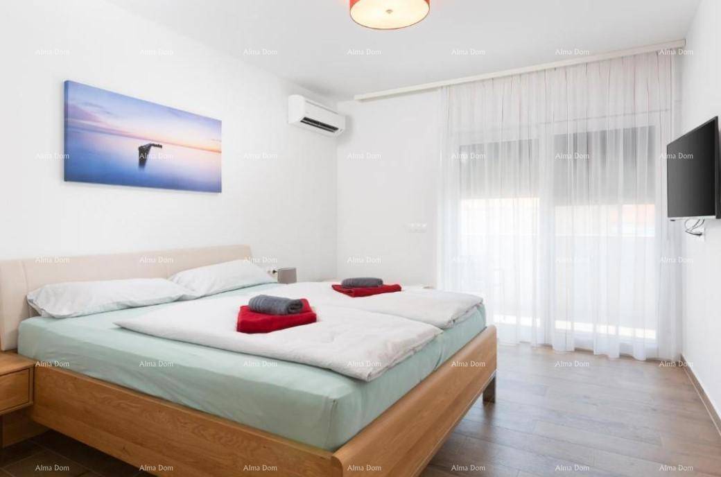 Helles Schlafzimmer mit hellem Holzdoppelbett, weißen Vorhängen und Klimaanlage.