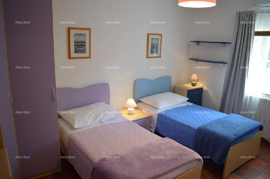 Kinderzimmer mit zwei Einzelbetten, lila Schrank und bunten Akzenten, hell und freundlich.