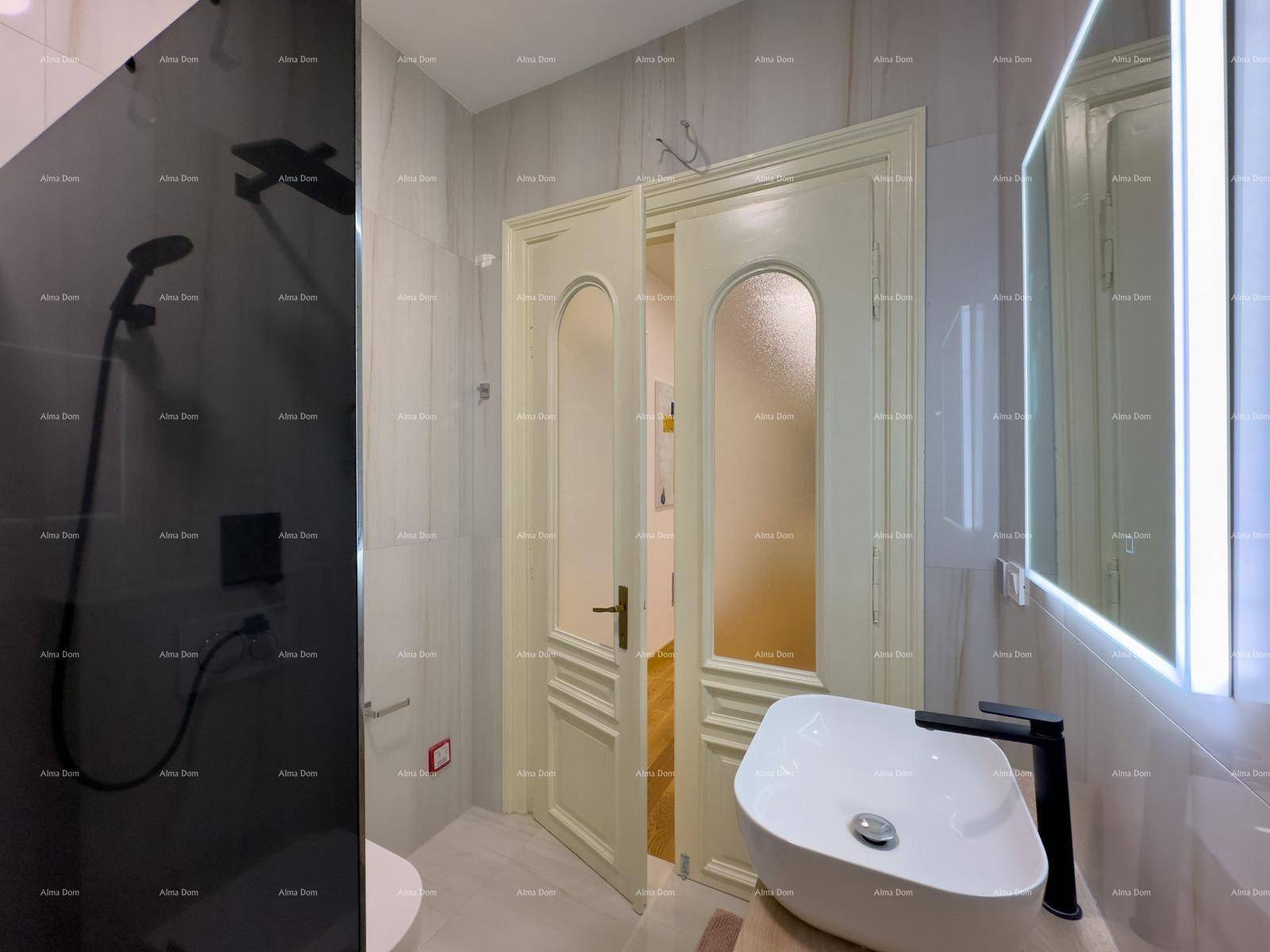 Modernes Badezimmer mit Waschbecken, beleuchtetem Spiegel und begehbarer Dusche.