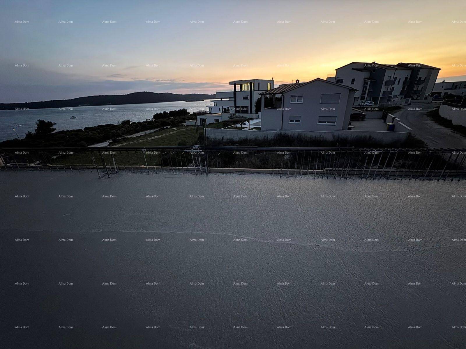 Luftaufnahme einer Baustelle bei Sonnenuntergang mit Blick auf das Meer und umliegende Häuser.