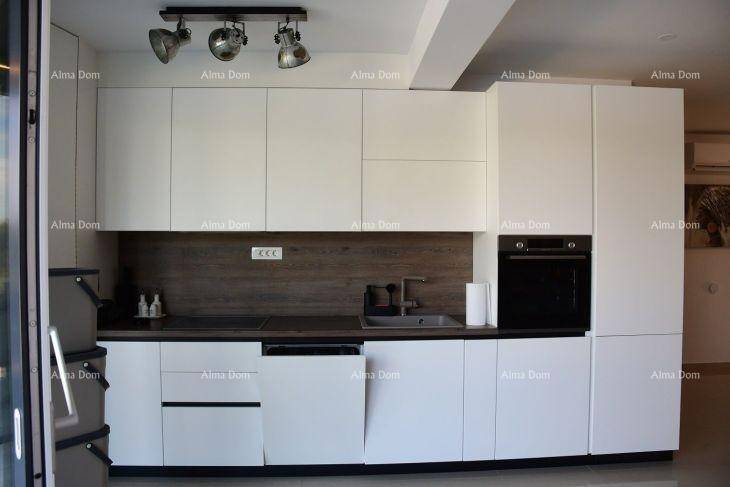 Moderne Einbauküche mit weißen Schränken, integrierten Geräten und dunkler Arbeitsplatte.