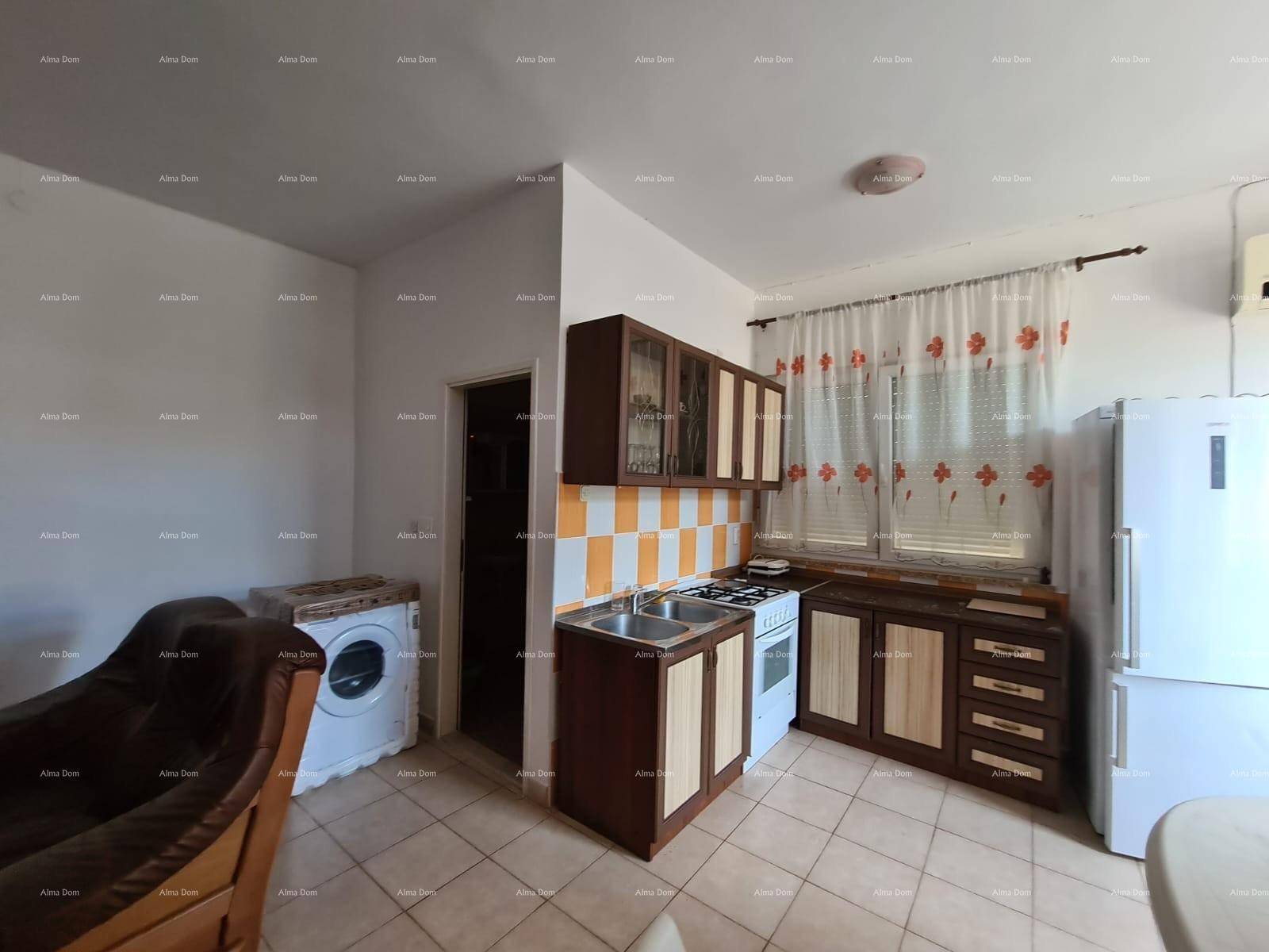 Küche mit dunklen Holzschränken, Herd und Kühlschrank, kombiniert mit einer Waschmaschine.
