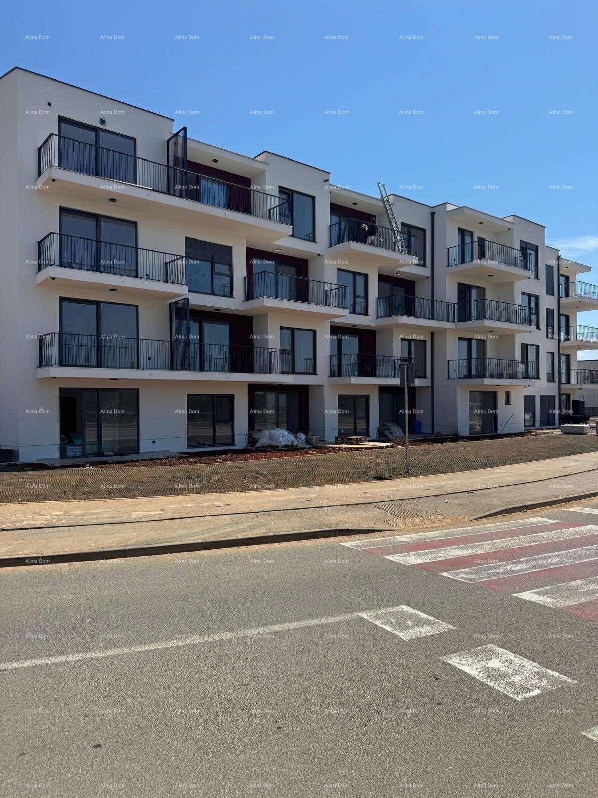Modernes Apartmentgebäude im Bau mit Balkonen und zukünftiger Straßenanbindung.