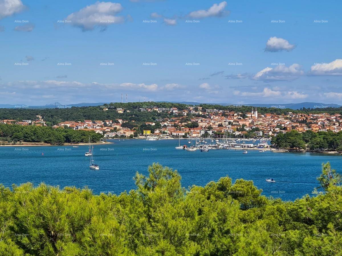 Malerischer Blick über die Bucht mit Yachthafen und Küstenstadt unter blauem Himmel.