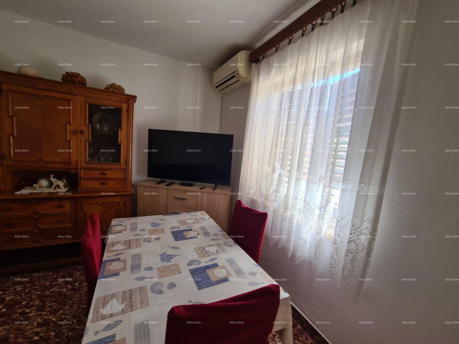 Heller Wohn-Essbereich mit Esstisch, Schrank und Fernseher, gut beleuchtet.
