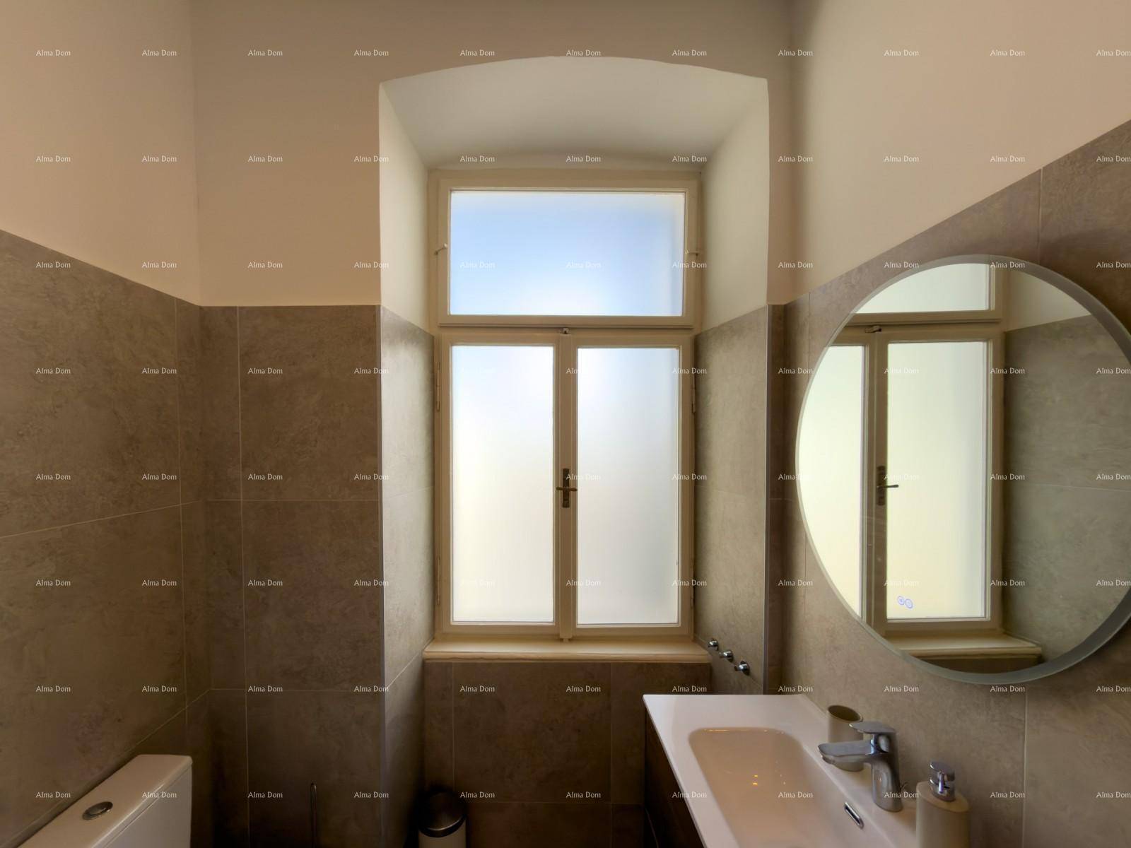 Badezimmer mit großem Fenster, modernem Waschtisch und rundem Spiegel für mehr Raumgefühl.
