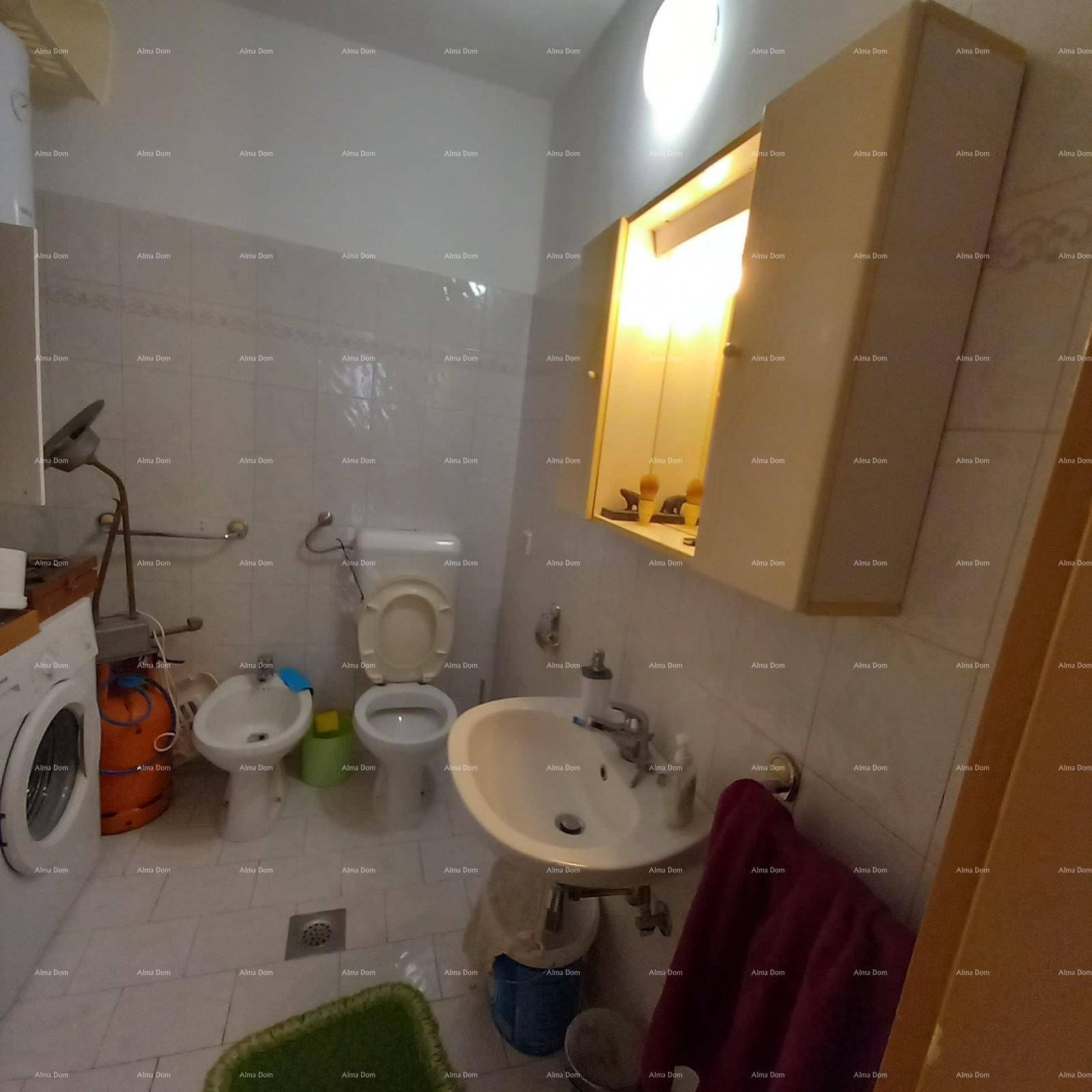 Badezimmer mit Fliesenboden, Toilette, Bidet und Waschmaschine.