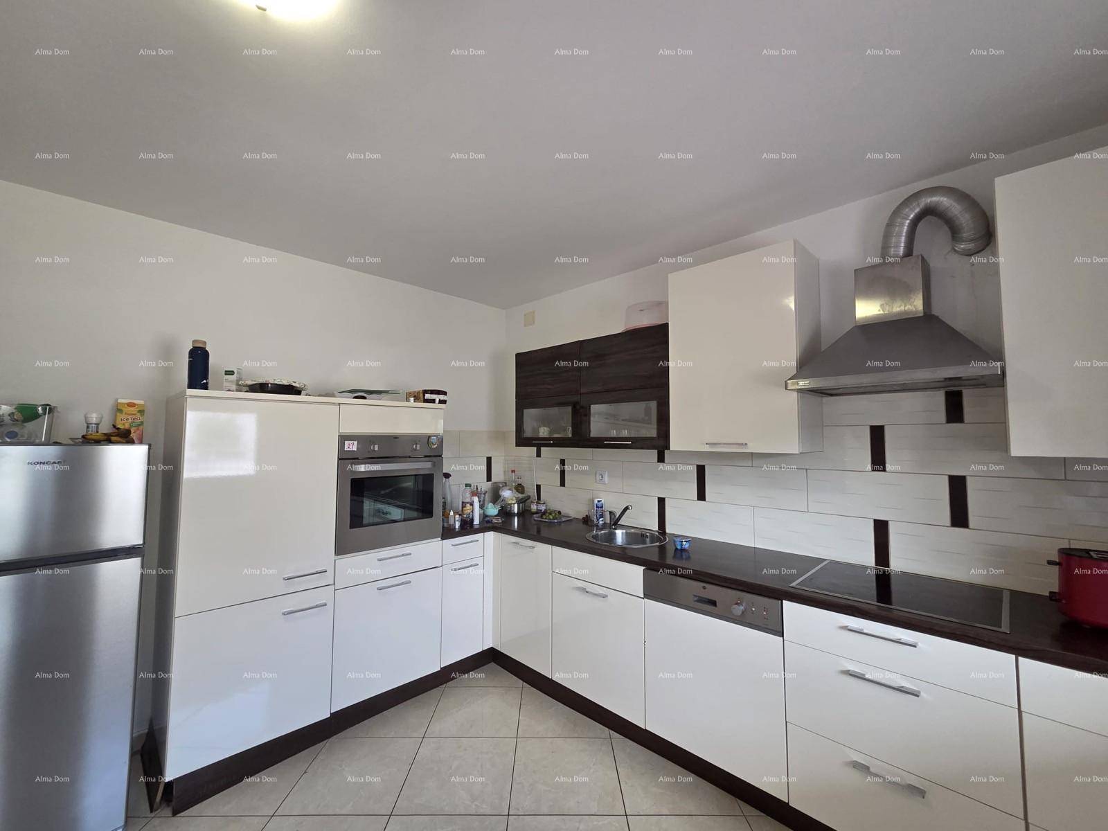 Moderne Einbauküche mit weißen Hochglanzfronten, dunkler Arbeitsplatte und integrierten Geräten.
