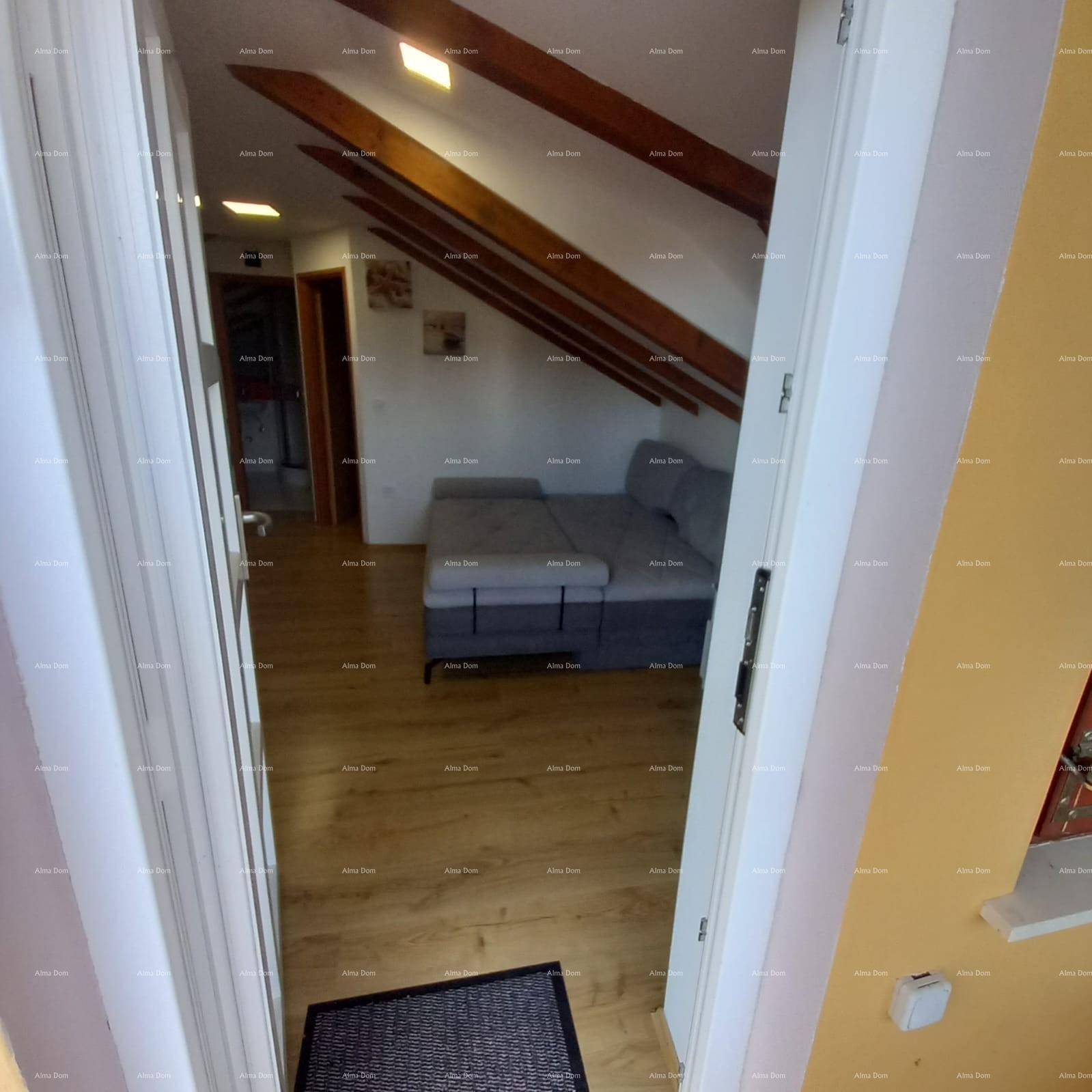 Gemütlicher Wohnbereich mit Schlafsofa unter Dachschrägen und Holzbalken.