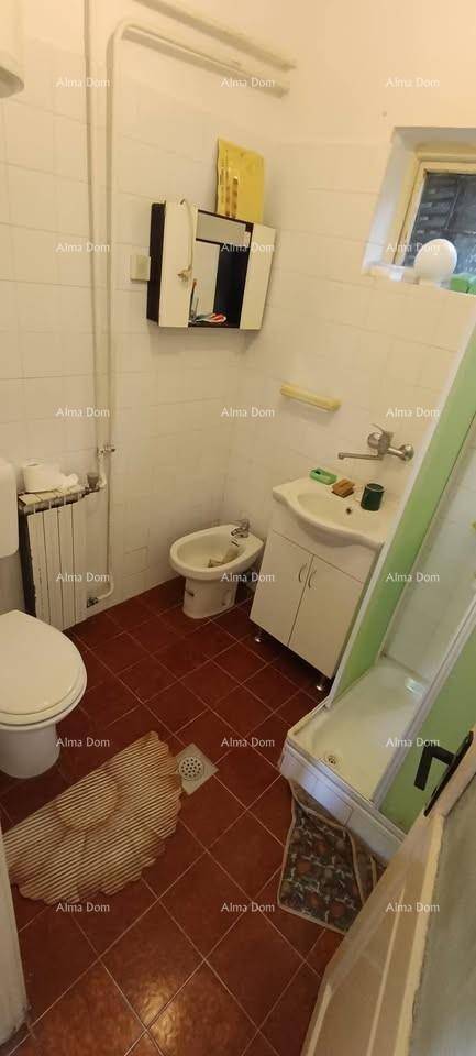 Badezimmer mit Toilette, Bidet, Waschbecken, Duschkabine und einem Fenster.