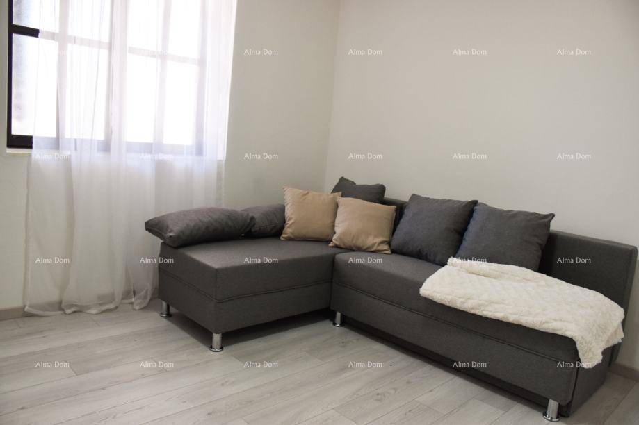 Gemütliches Ecksofa in einem hellen Wohnzimmer mit hellem Laminatboden und Fenster.