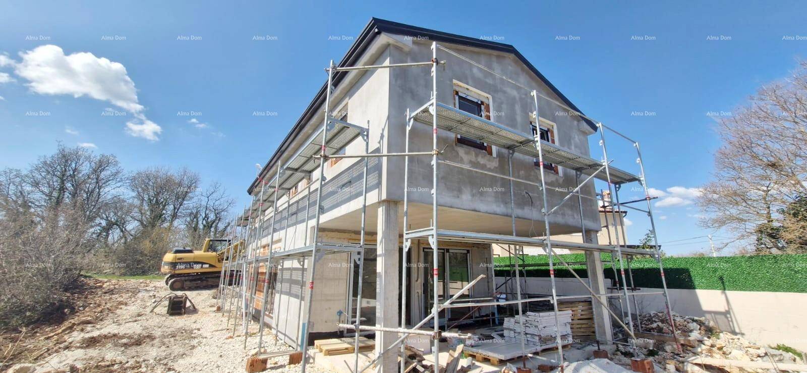 Baustelle eines Einfamilienhauses mit Gerüst und teilweise verputzter Fassade.