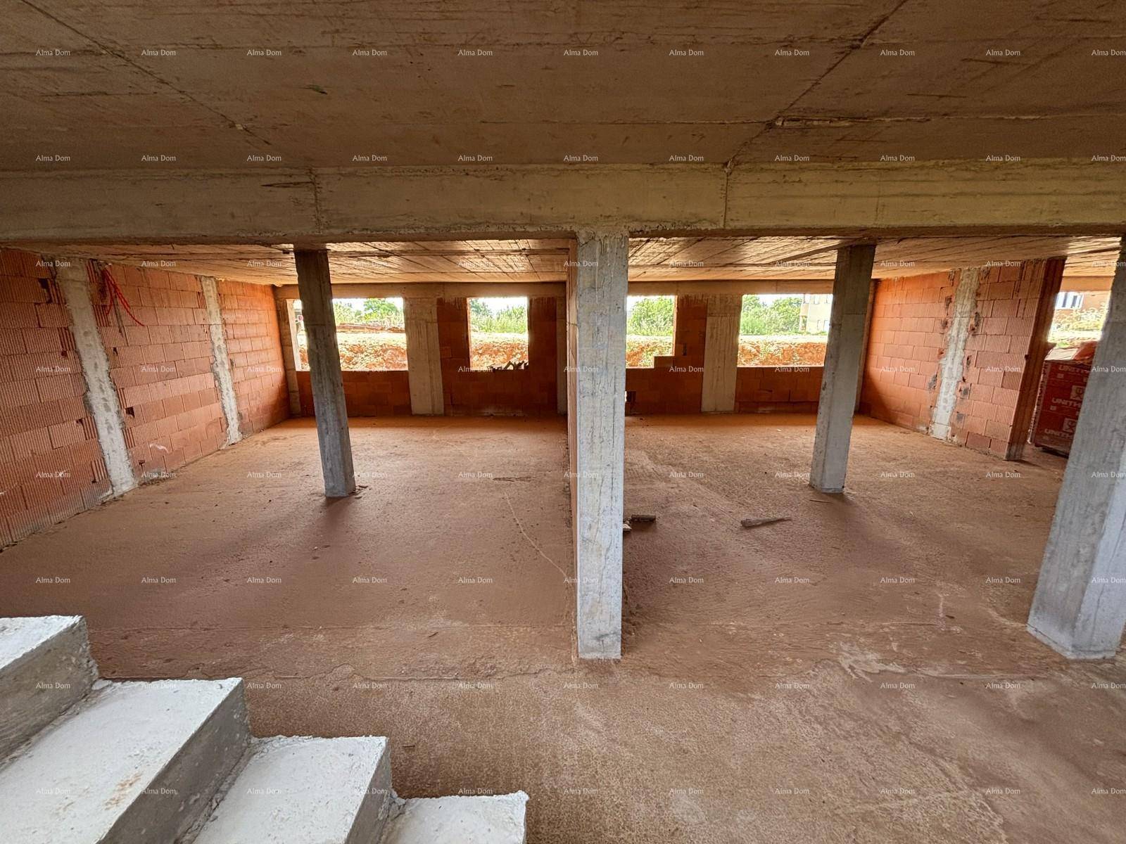 Unfertiger Innenraum eines Neubaus mit Betonboden, Säulen und unverputzten Ziegelwänden.