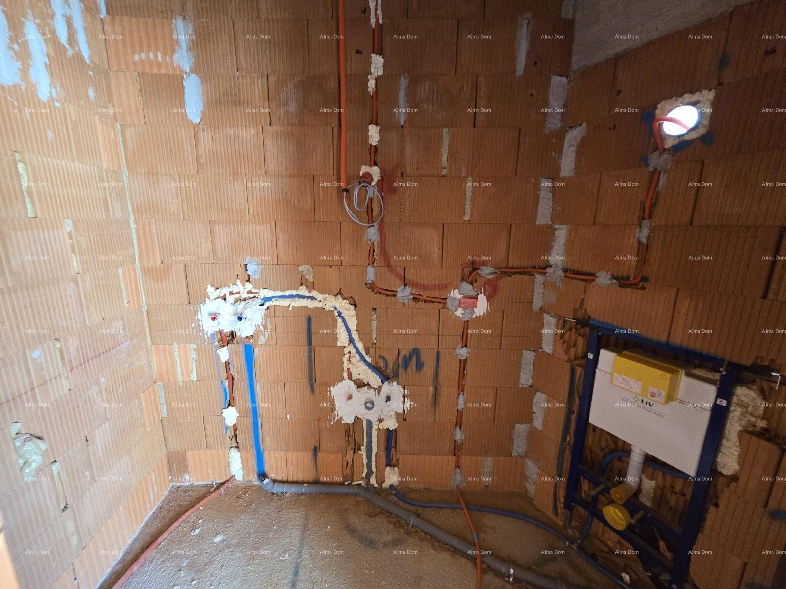 Badezimmer im Rohbau mit Ziegelwänden und vorbereiteten Sanitärinstallationen.