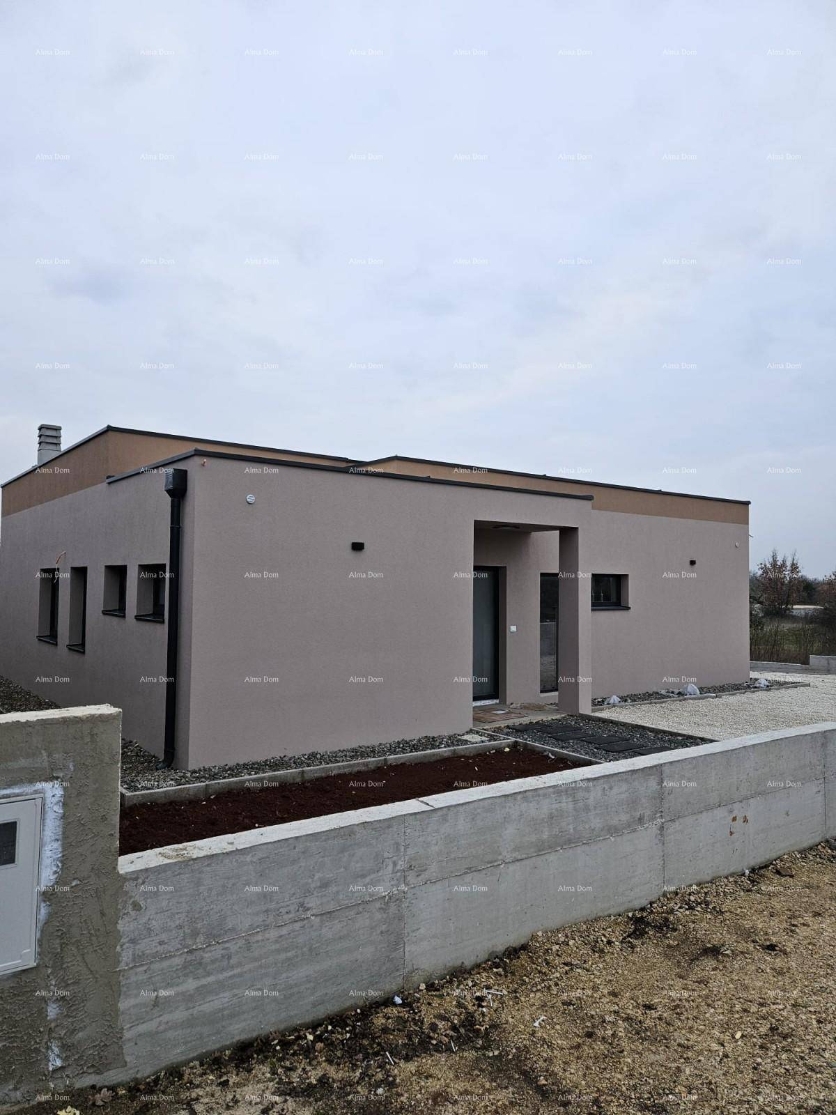 Ansicht des modernen Einfamilienhauses mit beigefarbener Fassade und einer Betonmauer im Vordergrund.