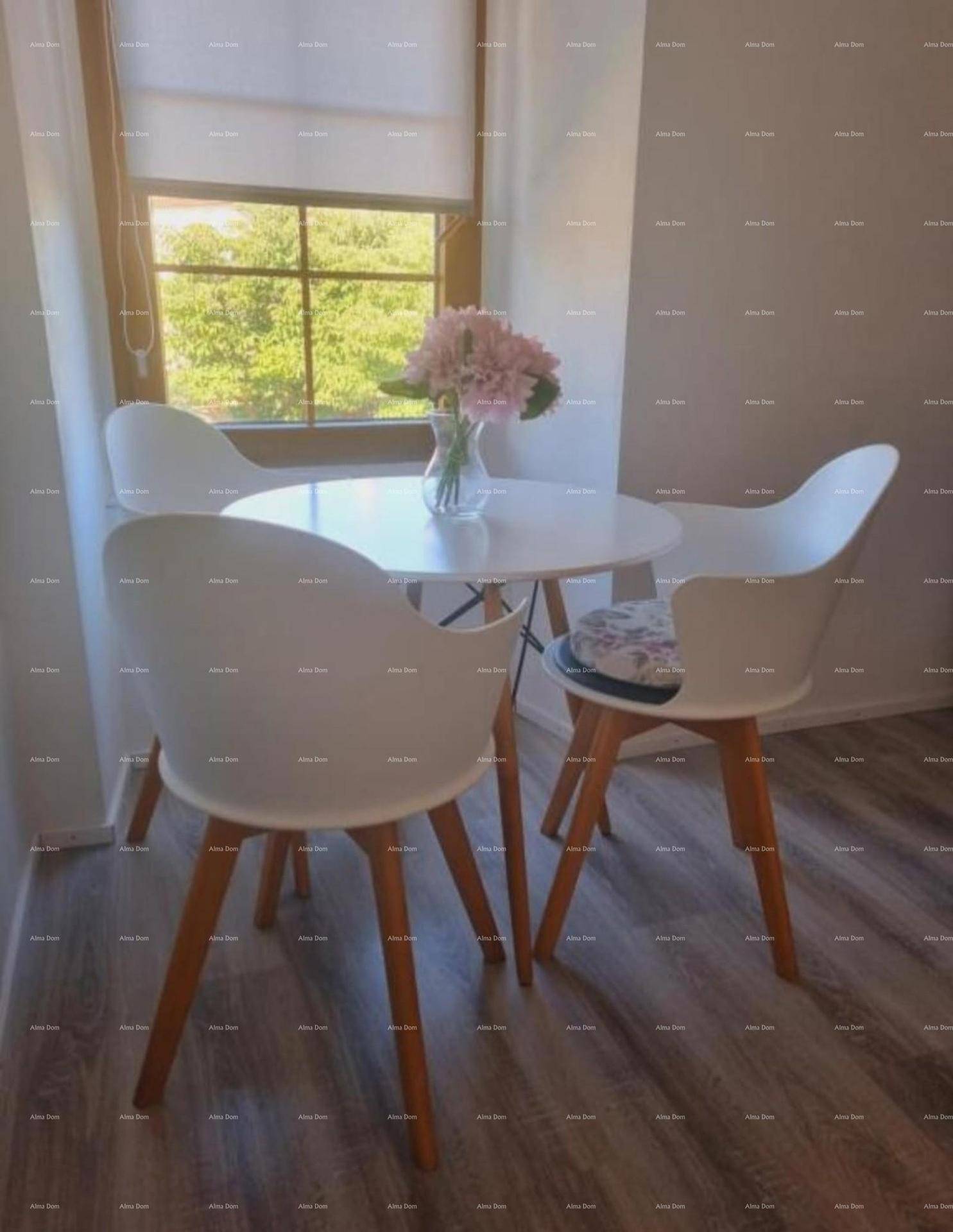 Heller Essbereich mit kleinem runden Tisch und modernen weißen Stühlen am Fenster.