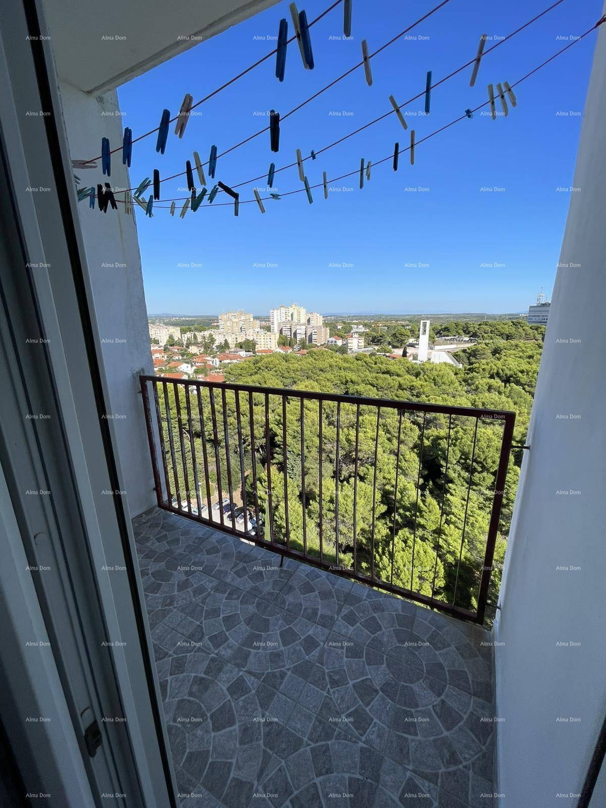 Balkon mit Stadtblick und Wäscheleinen unter blauem Himmel.