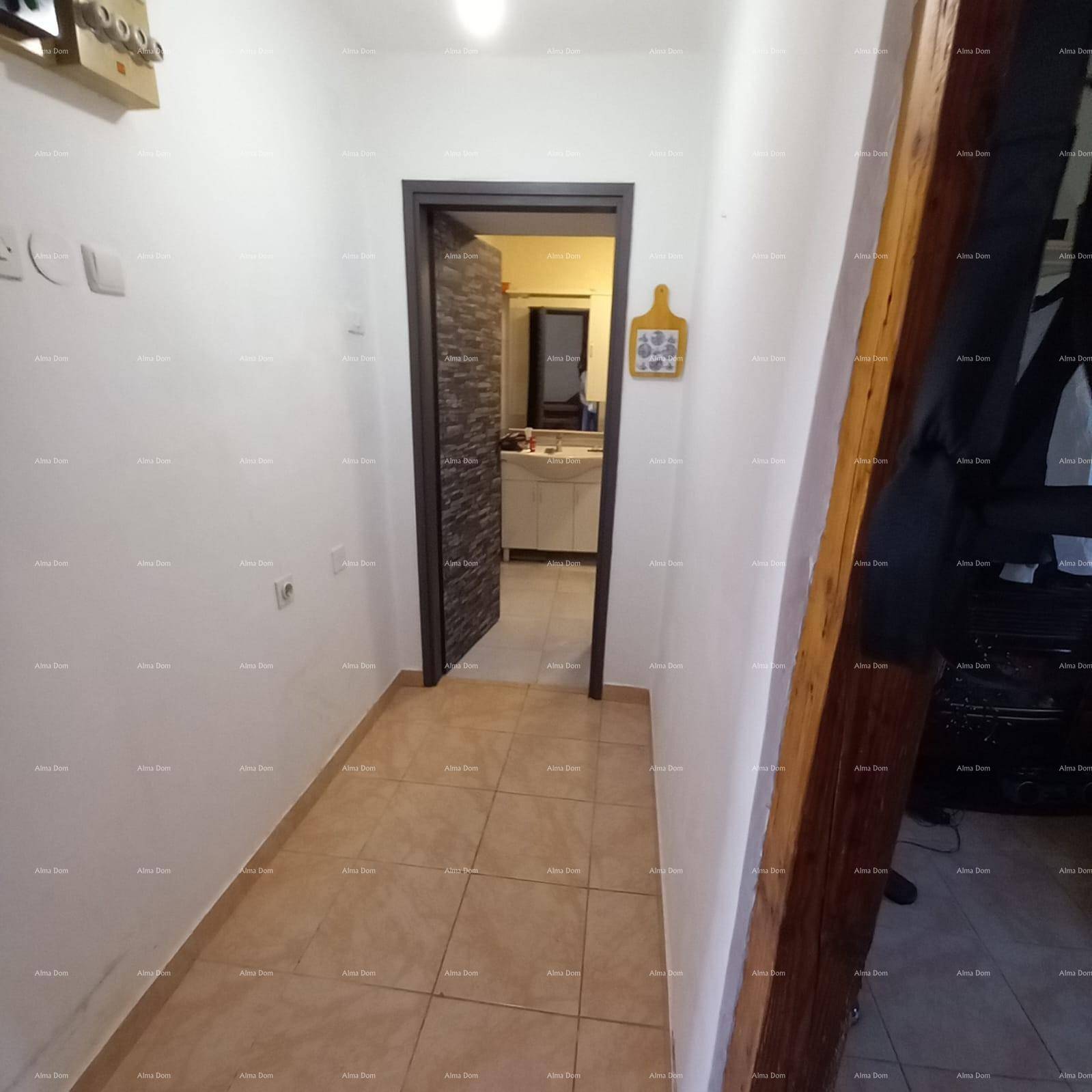 Heller Flur mit Fliesenboden, der zu einem Badezimmer mit moderner Einrichtung führt.