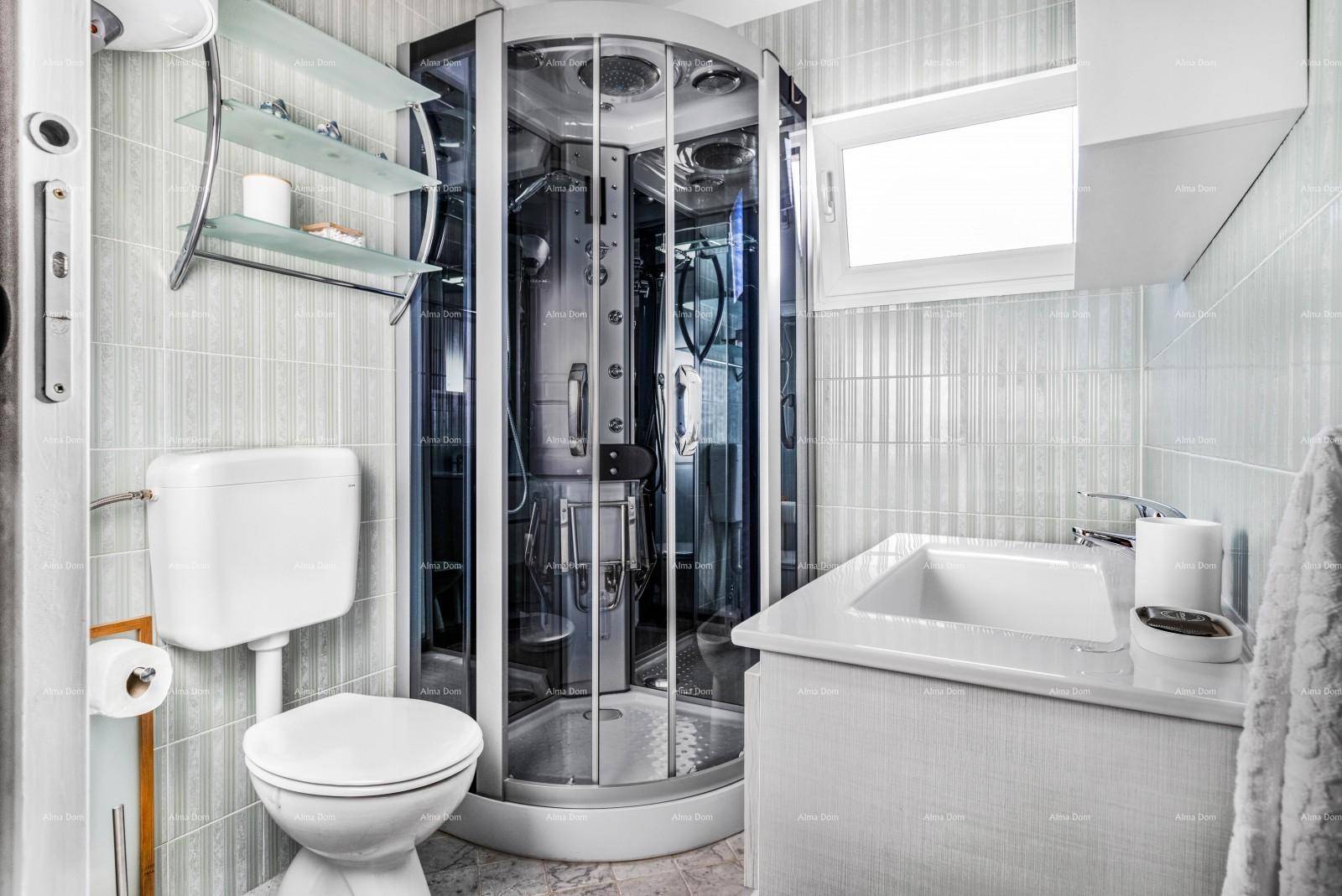 Modernes Badezimmer mit Duschkabine, WC und hellen Fliesen an Wänden und Boden.