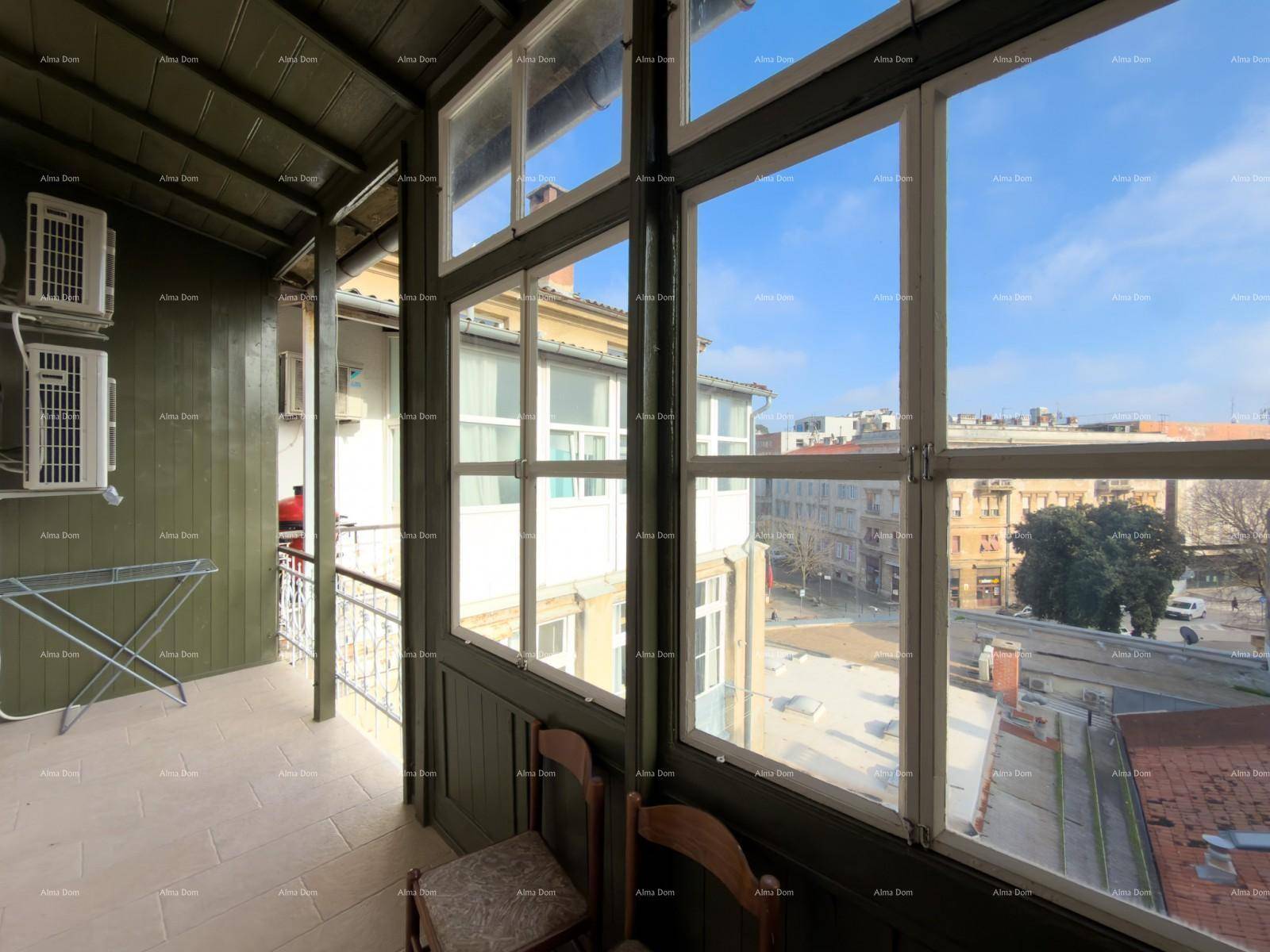 Verglaste Loggia mit Stadtblick und grünen Holzverkleidungen, ideal zum Entspannen.