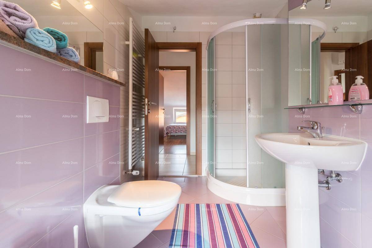 Modernes Badezimmer im Dachgeschoss mit runder Duschkabine, Bidet und lila Fliesen.