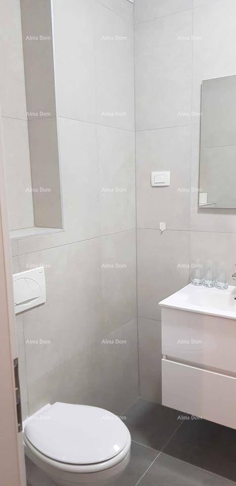 Modernes Badezimmer mit Wand-WC, Waschbecken und großen grauen Fliesen an Wänden und Boden.