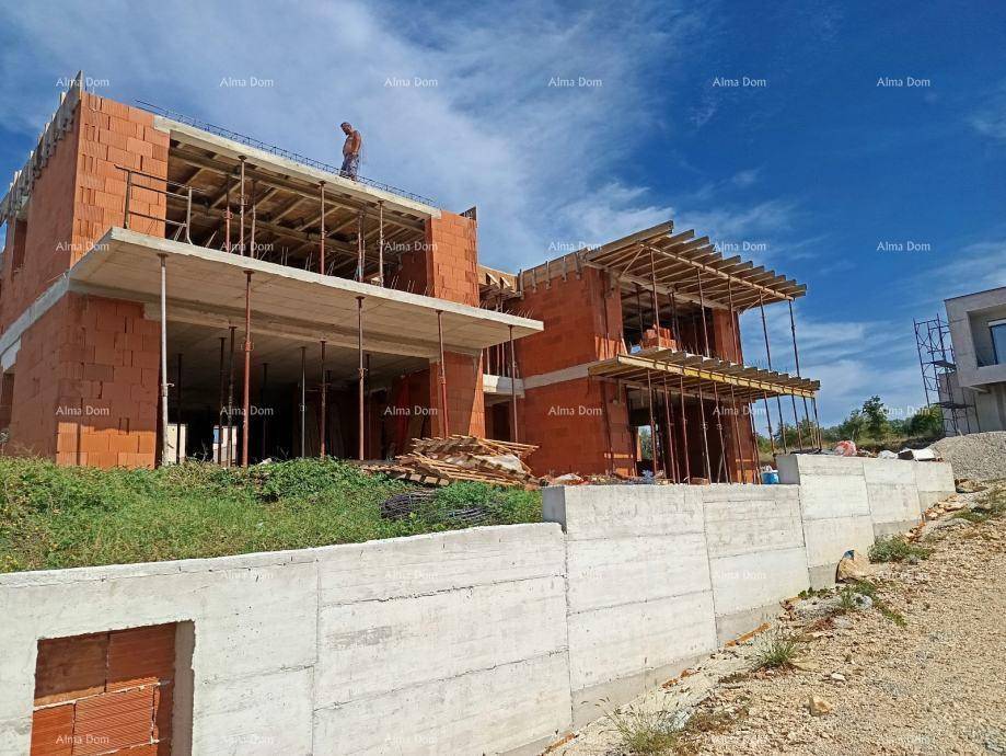 Baustelle eines Neubaus mit sichtbaren Ziegelwänden, Betonelementen und Stützmauern.