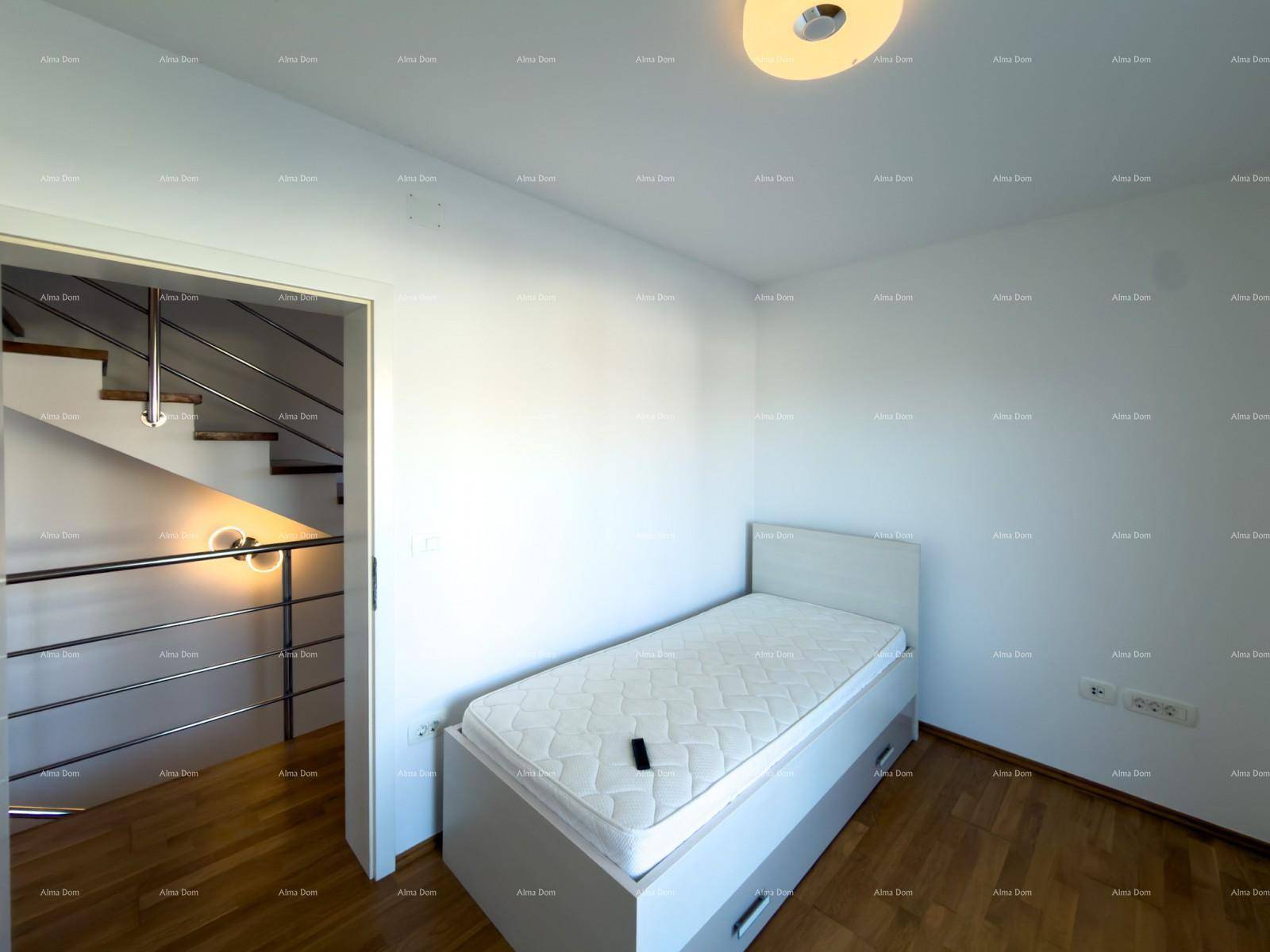 Schlafzimmer mit Holzboden und Blick auf den Treppenaufgang.