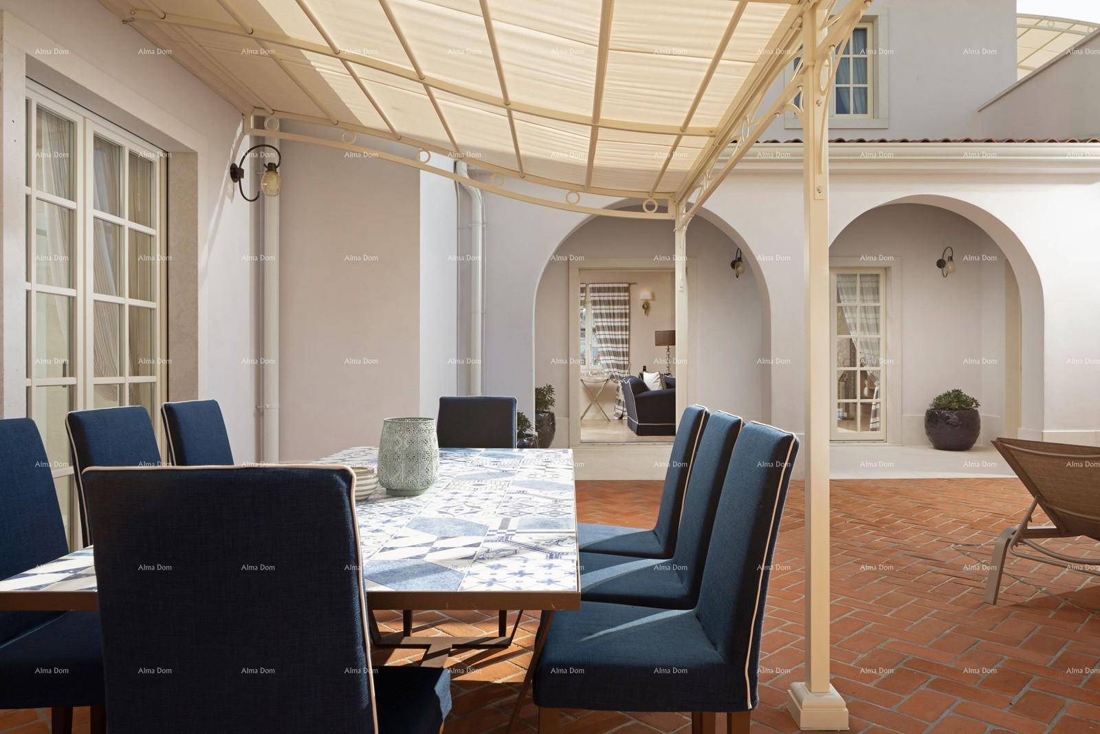 Gemütlicher Essbereich im Freien unter einer Pergola mit Blick auf den Innenhof.