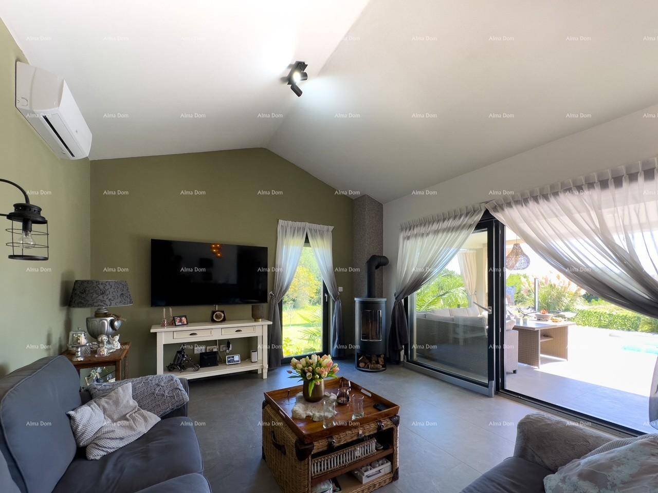 Modernes Wohnzimmer mit Kaminofen, Klimaanlage und großen Schiebetüren zur Terrasse und zum Pool.