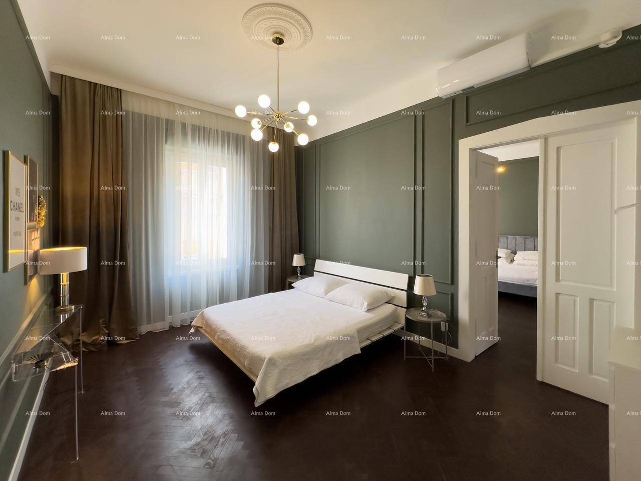 Geräumiges Schlafzimmer mit dunklem Parkettboden, grünen Wandpaneelen und einem modernen Doppelbett.