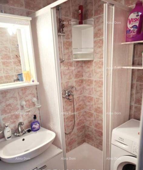 Badezimmer mit Duschkabine, Waschbecken und Waschmaschine, geflieste Wände.