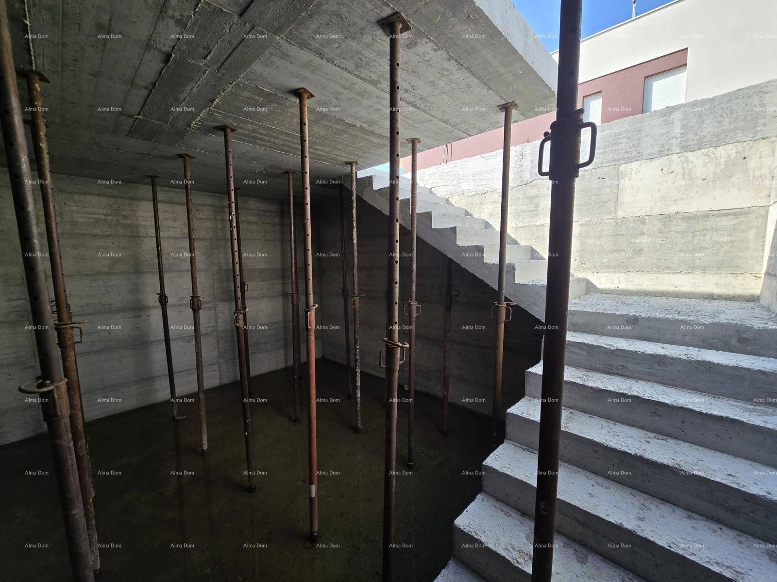 Unfertiger Kellerraum mit zahlreichen Metallstützen, die die Betondecke tragen, und einem Treppenaufgang.