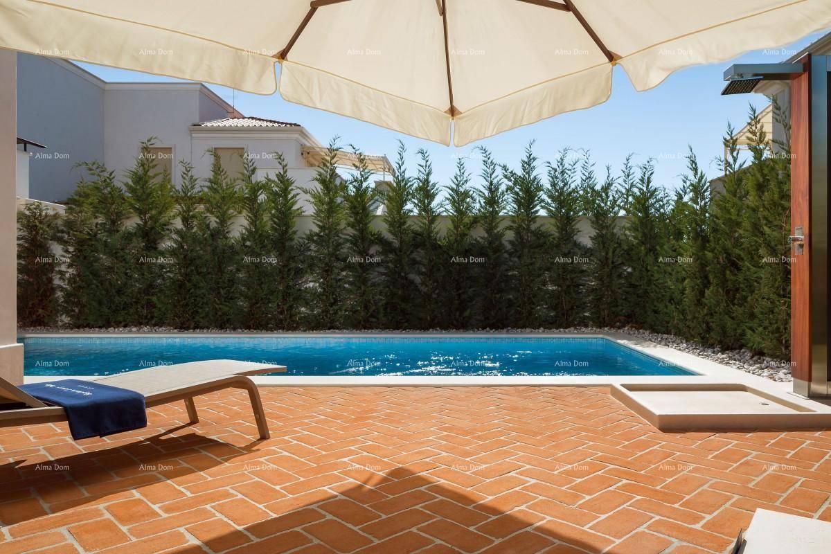 Entspannender Poolbereich mit Liegestühlen, Sonnenschirm und grüner Hecke für Privatsphäre.