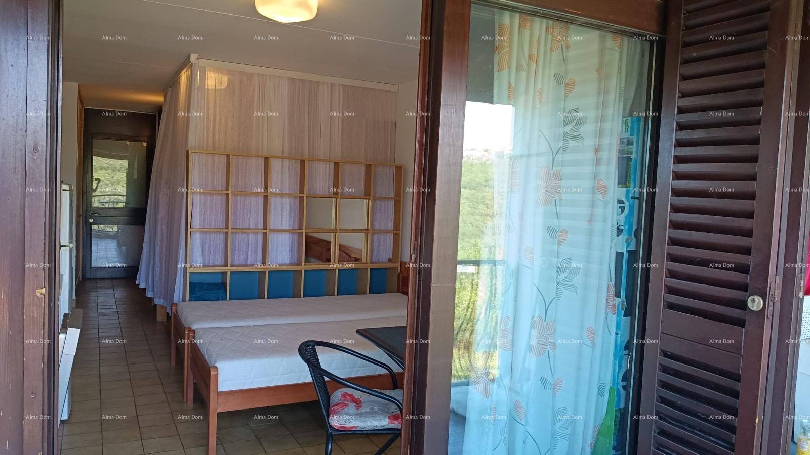 Schlafbereich mit zwei Einzelbetten und direktem Zugang zum Balkon, hell und funktional eingerichtet.