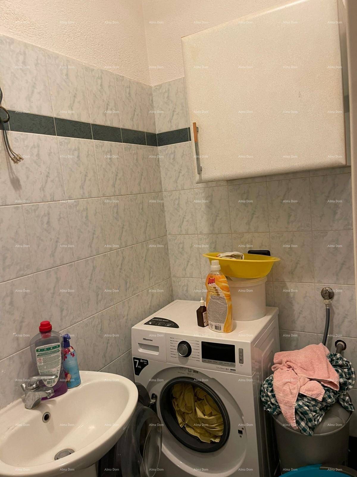 Kleiner Hauswirtschaftsraum mit Waschmaschine, Waschbecken und gefliesten Wänden, praktisch und funktional.