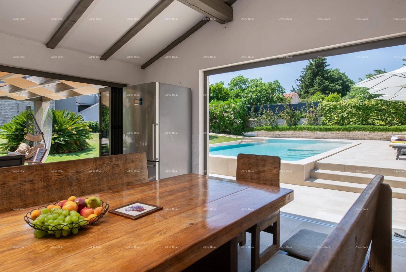 Heller Essbereich mit großem Holztisch und direktem Blick auf den Pool und Garten.